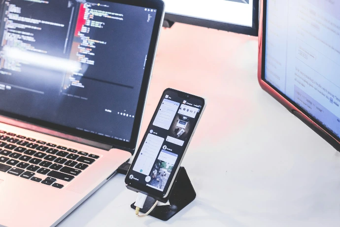 a cell phone and a laptop on a desk